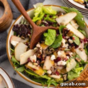 Pomegranate salad with pears, pomegranate seeds, and golden raisins on top.