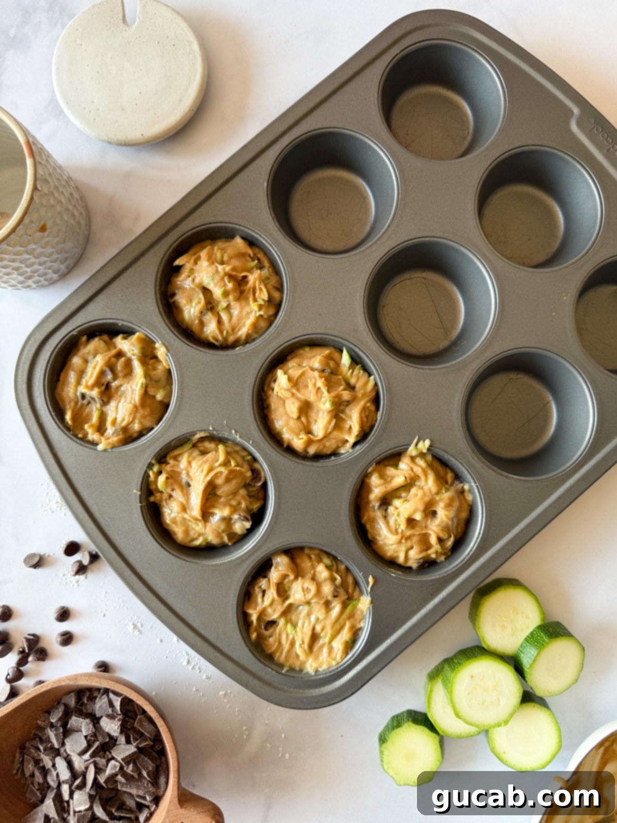 Heartwarming Zucchini Muffins 13 Zucchini muffin batter in a muffin tin, ready to be baked.