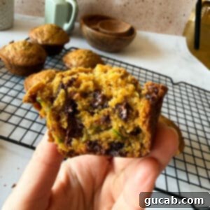 Heartwarming Zucchini Muffins 16 hand holding half a zucchini muffin
