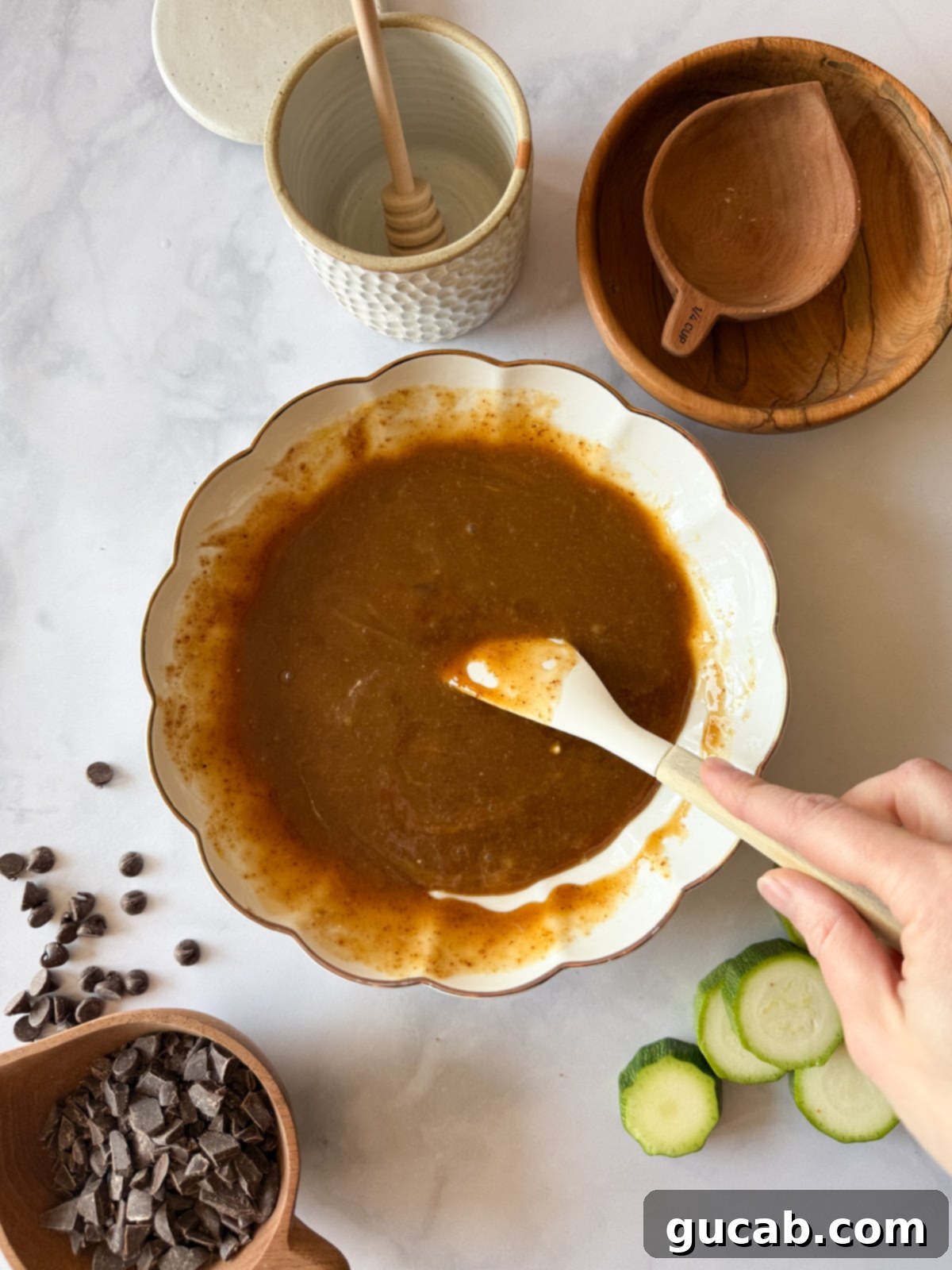 Heartwarming Zucchini Muffins 8 Greek yogurt, egg, coconut sugar, maple syrup, and coconut oil mixed together in a bowl, creating a smooth and creamy base for the muffins.