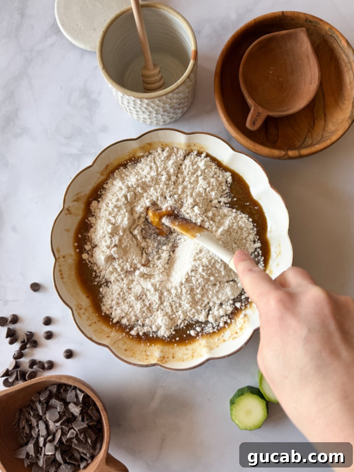Heartwarming Zucchini Muffins 9 Gluten-free flour on a bowl of mixed egg, maple syrup, and coconut oil, ready to be incorporated into the batter.