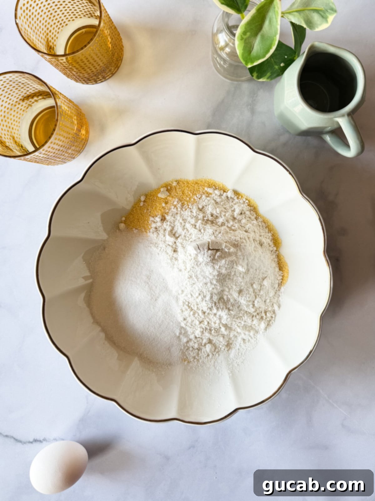 Dry ingredients for gluten-free cornbread in a bowl: cornmeal, gluten-free flour, sugar, baking powder, and baking soda.