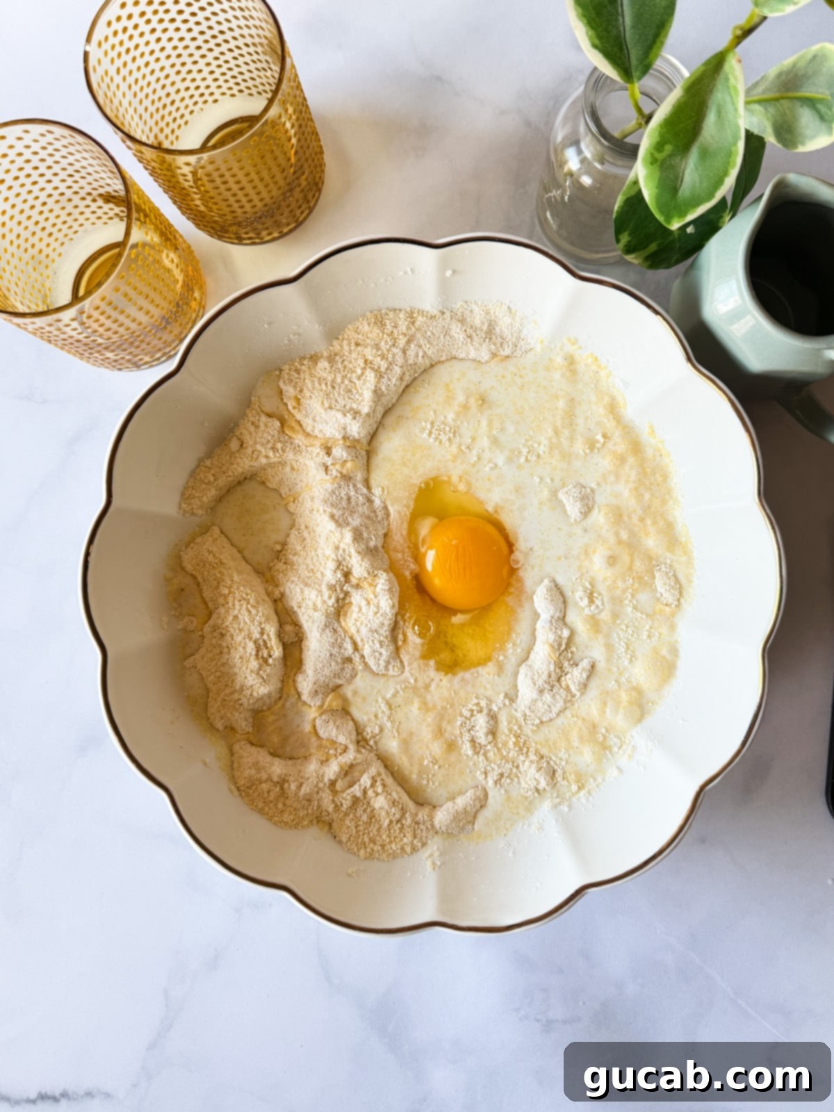 Wet ingredients being added to the dry ingredients for gluten-free cornbread.