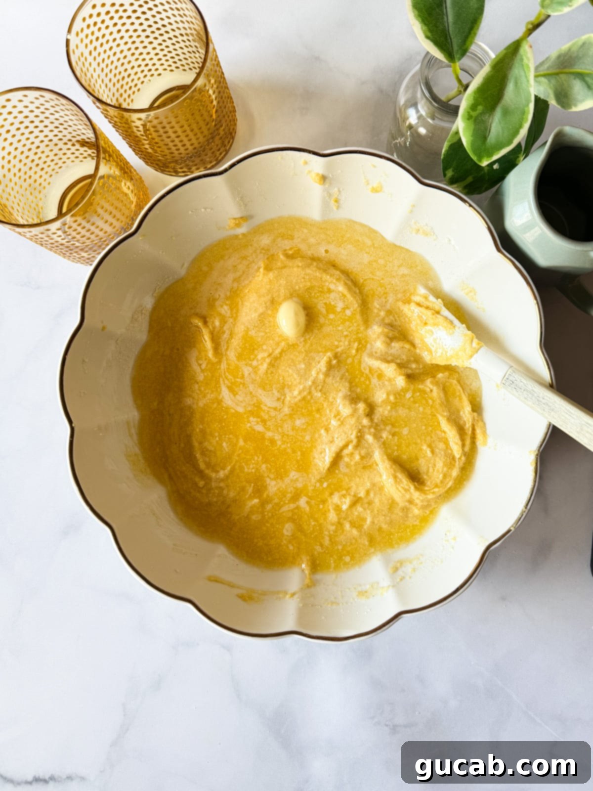 Melted butter being poured on top of the gluten-free cornbread batter.