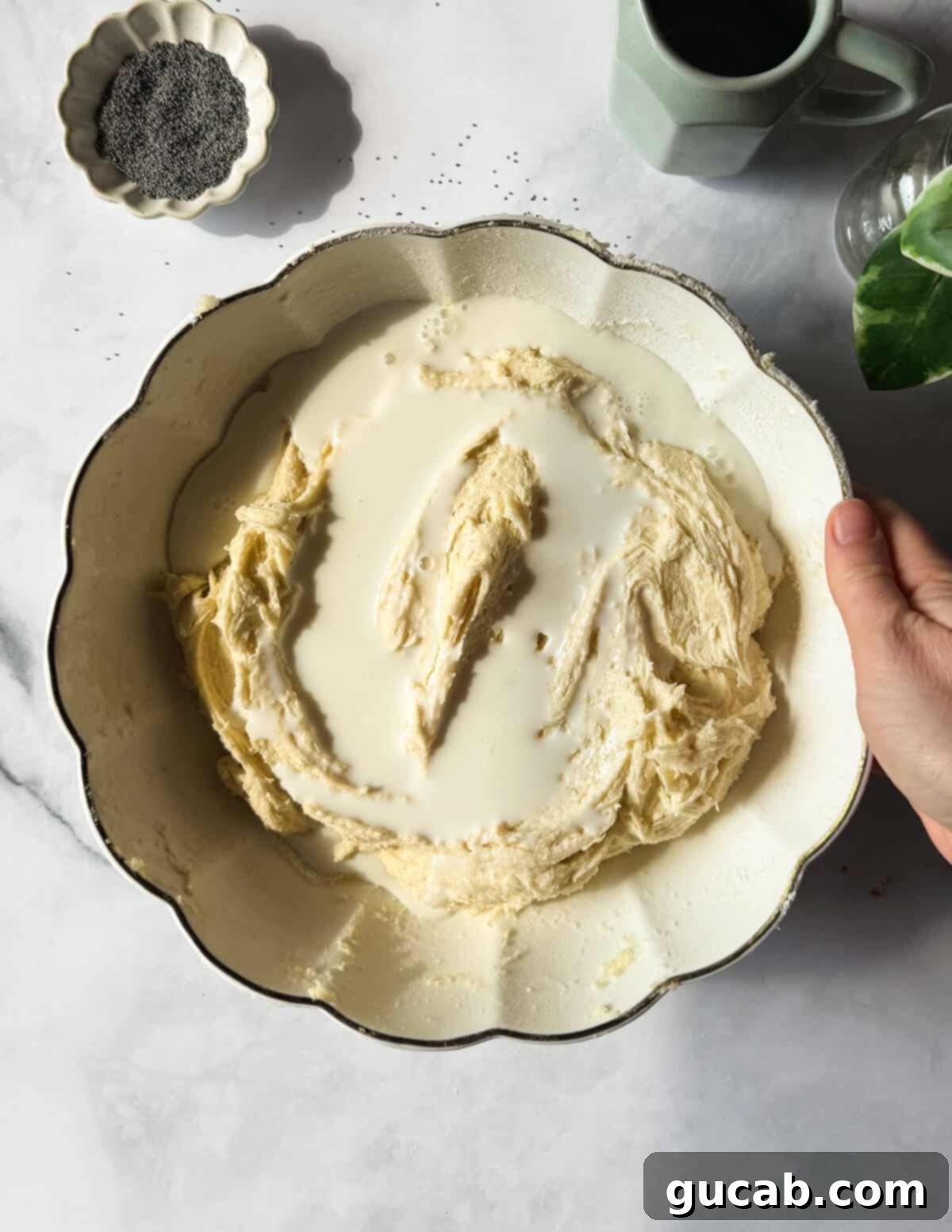 Lemon Poppyseed Bliss: A Gluten-Free Delight 12 A bowl of gluten-free cake batter with whole milk on top, ready to be mixed in.