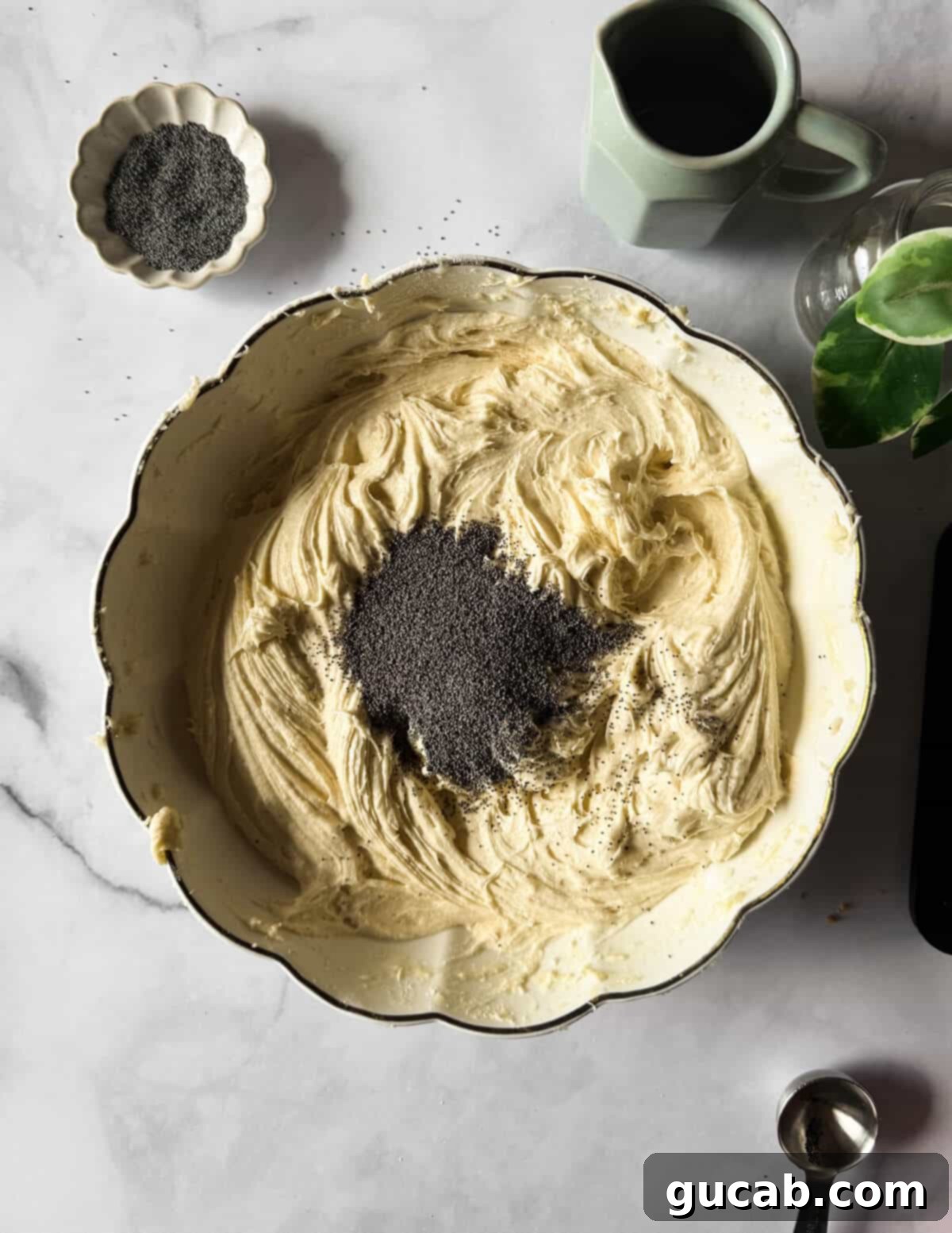 Lemon Poppyseed Bliss: A Gluten-Free Delight 14 A bowl of gluten-free cake batter with poppy seeds on top, ready to be mixed in.