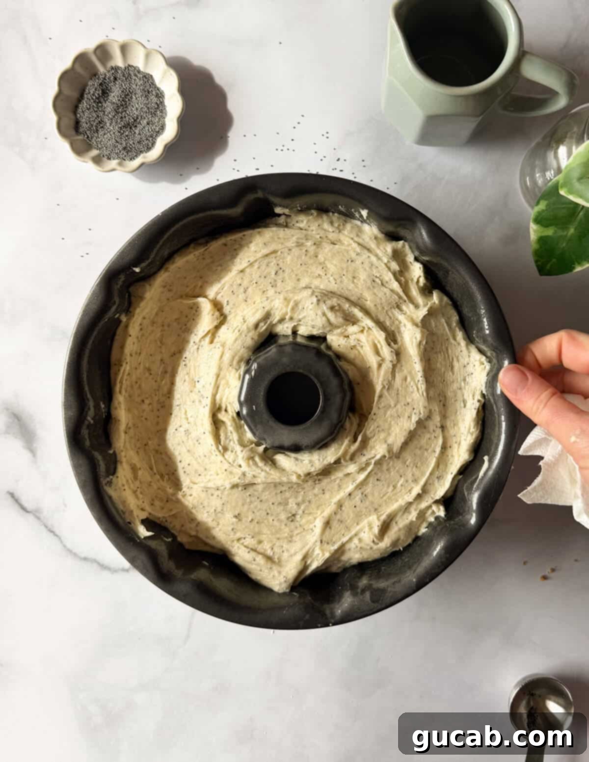 Lemon Poppyseed Bliss: A Gluten-Free Delight 15 Gluten-free lemon poppyseed cake batter in a greased bundt pan, ready to be baked.