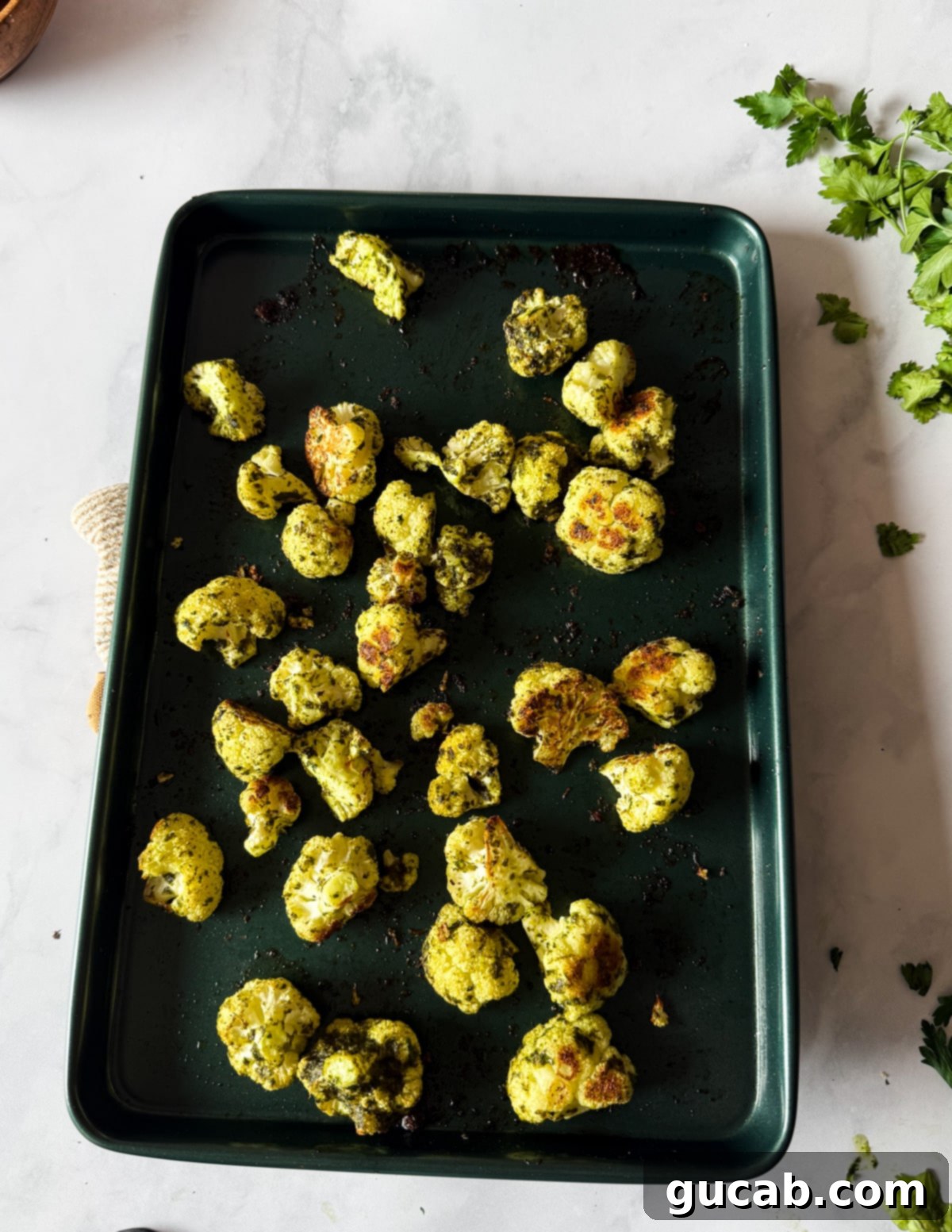 Herb-Crusted Roasted Cauliflower 9 Perfectly herb roasted cauliflower florets on a sheet pan, showcasing their golden-brown color.