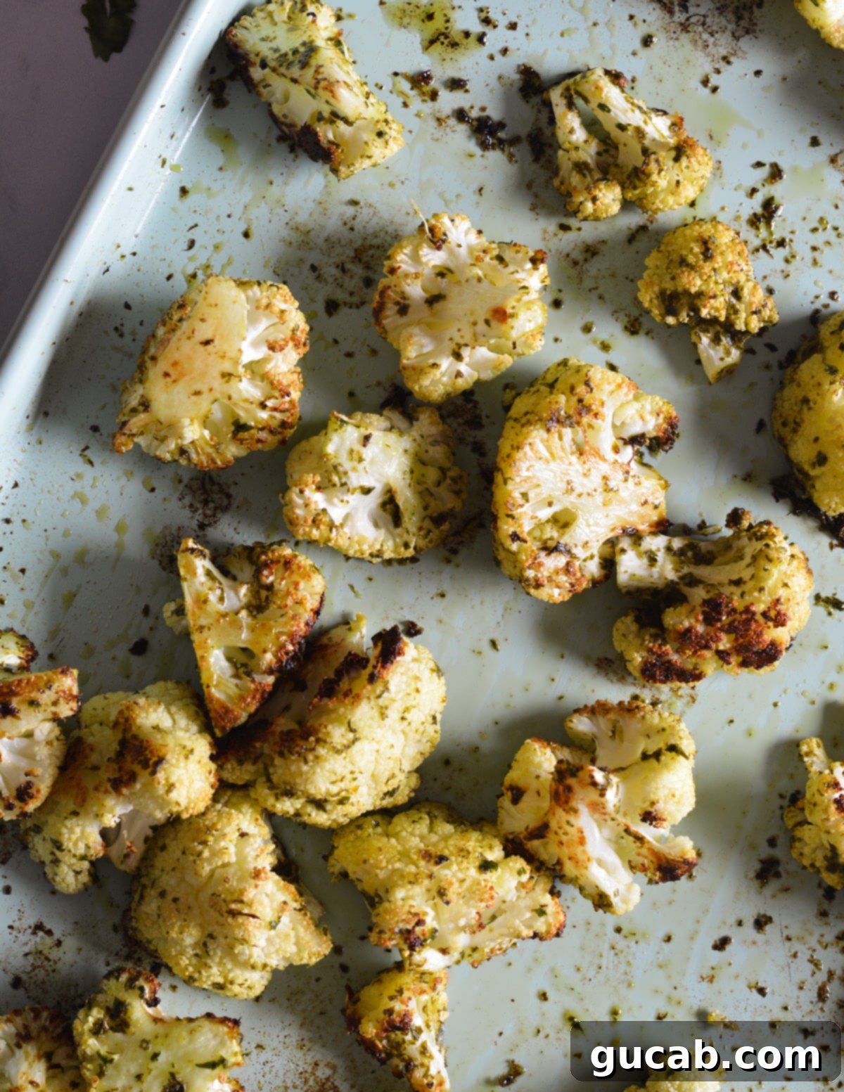 Herb-Crusted Roasted Cauliflower 10 Close-up of golden-brown herb roasted cauliflower florets on a sheet pan, ready to be served.